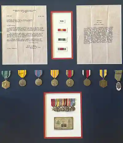 Military medals and documents displayed on wall.